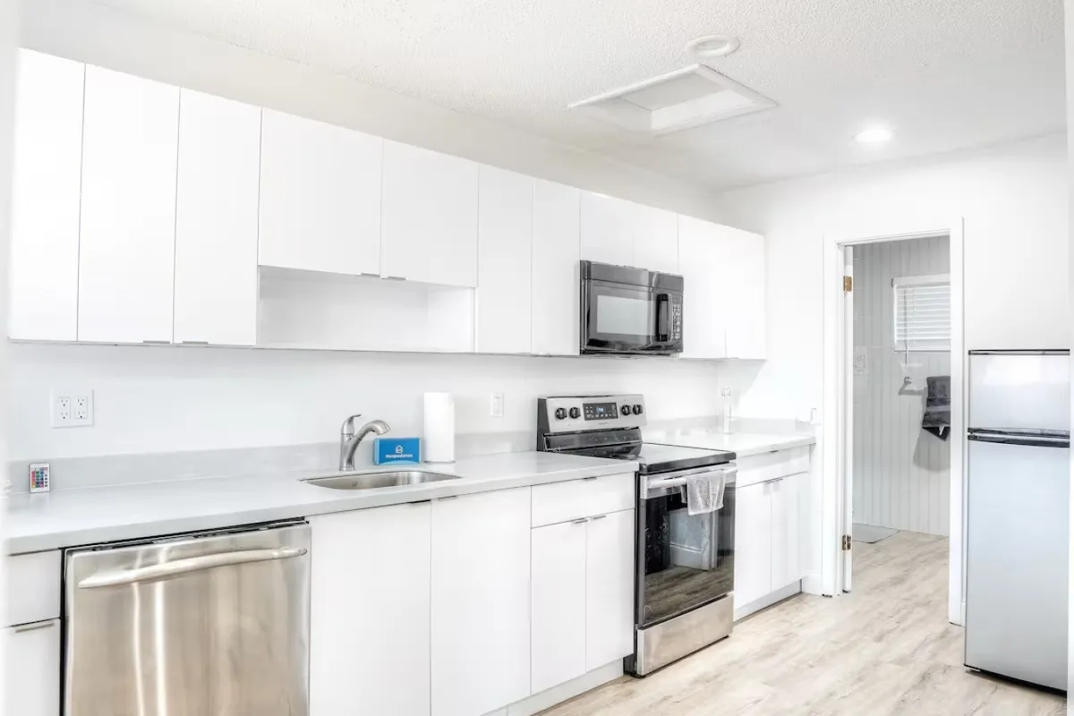 A bright, inviting kitchen space featuring sleek stainless steel appliances, crisp white cabinetry, and ample countertop space. The layout is functional and open, ideal for meal prep or hosting small gatherings.