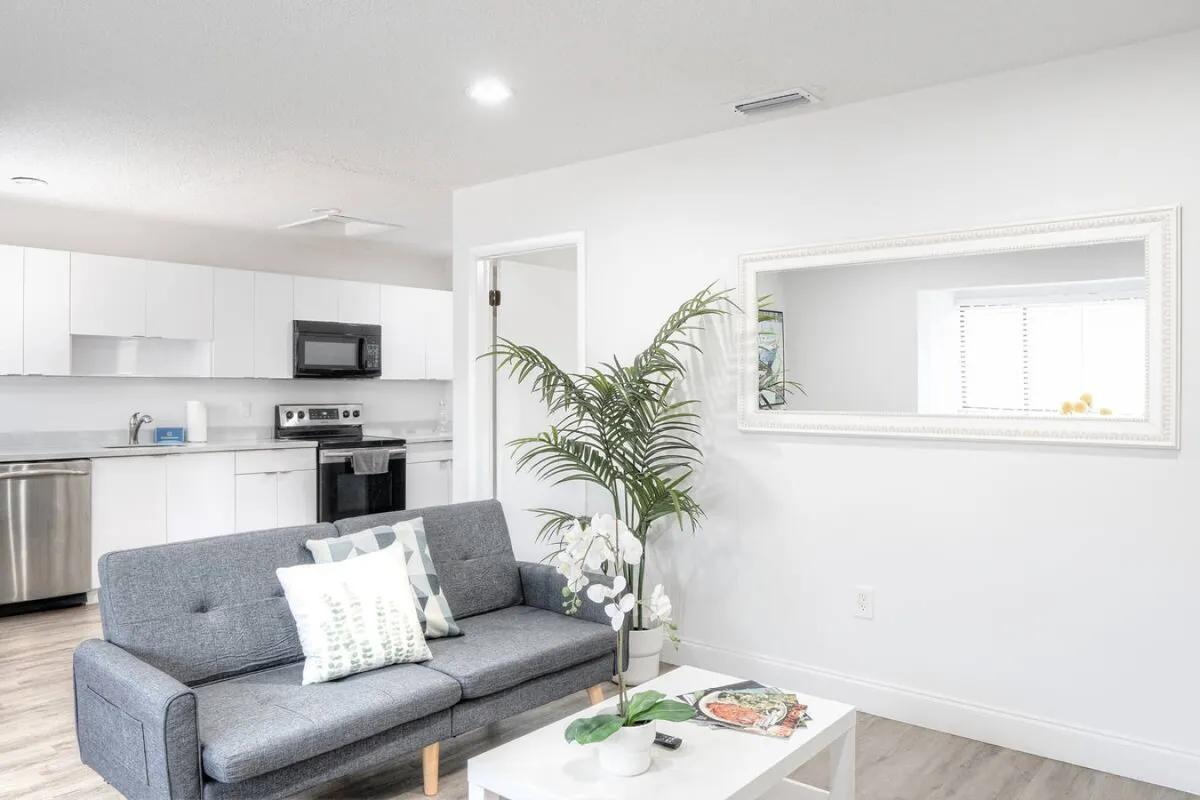A calm and orderly view of the kitchen showing a stainless steel dishwasher, a sink with faucet, an electric stove with oven, and a black microwave above the stove. The space is clean, functional, and designed for productivity, making it ideal for preparing meals or snacks at any time.